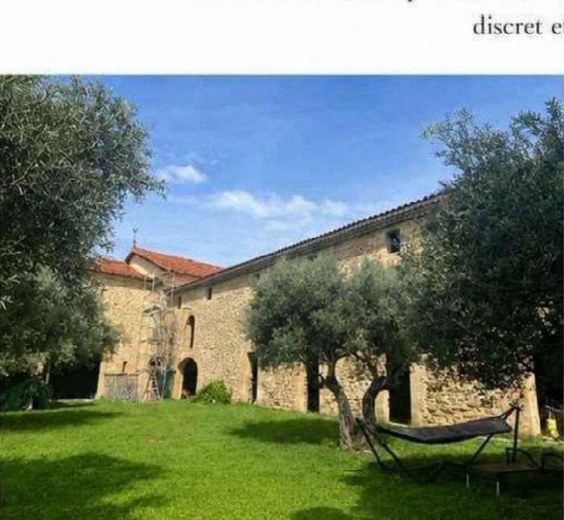 Cour engazonnée bordée par les ailes de la bâtisse